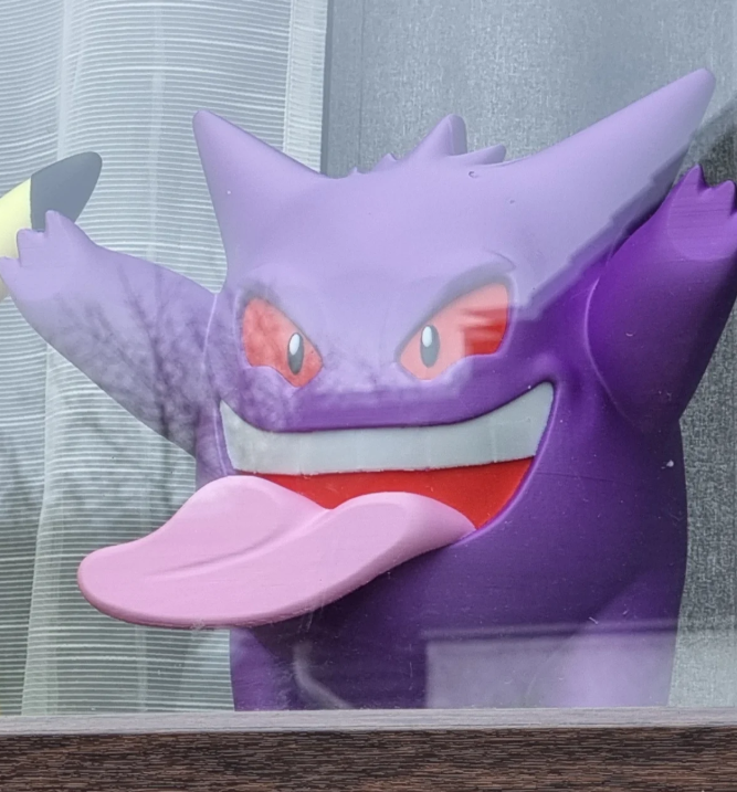 Purple cartoon character with a wide open mouth on a gray background