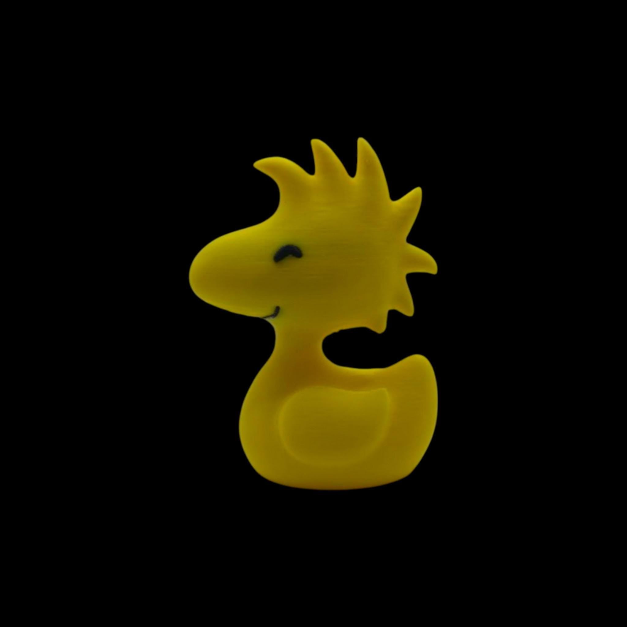 A yellow figurine of Woodstock from Peanuts, with spiky head feathers, a small beak, and two black dots for eyes, facing left.