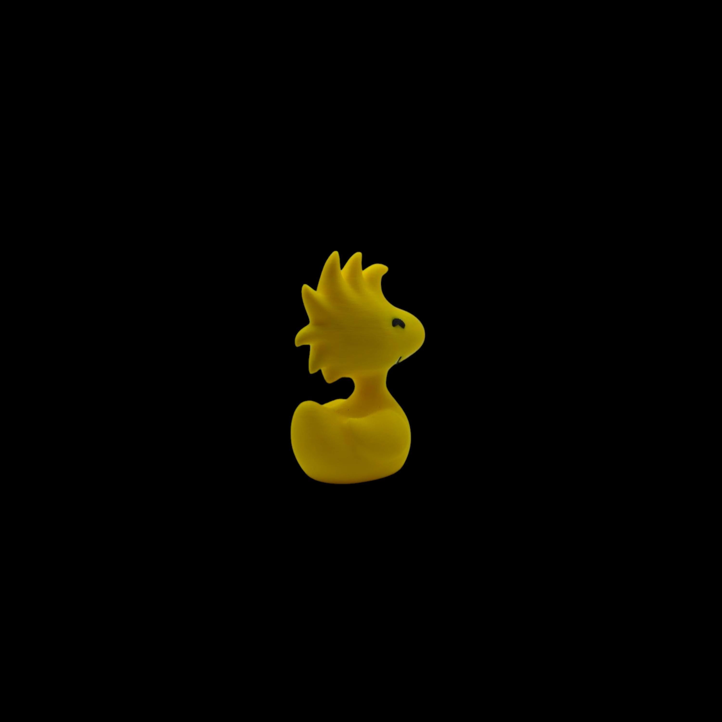 A small yellow figurine of Woodstock from Peanuts, with spiky head feathers and a small beak, facing left.