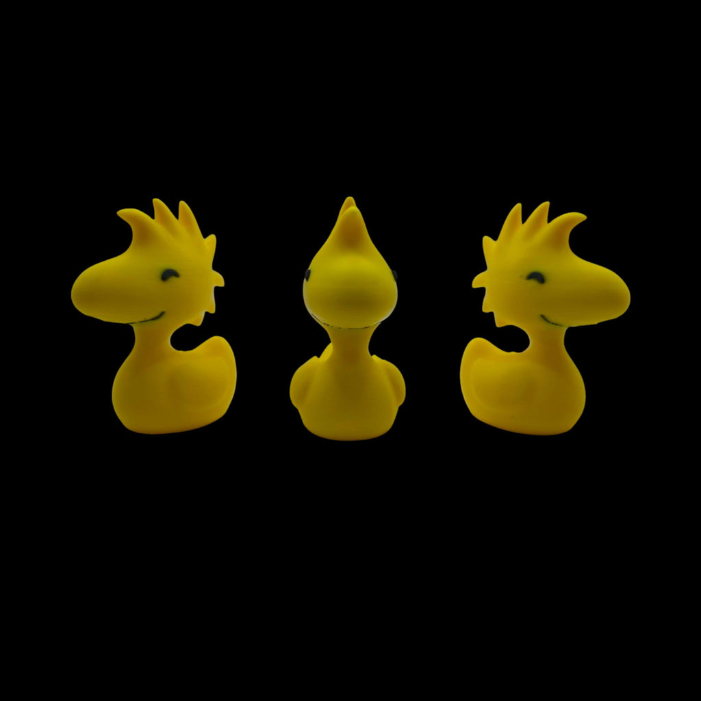 Three yellow Woodstock duck figurines are shown from slightly different angles, with the center one facing forward and the outer two facing left and right, against a black background.