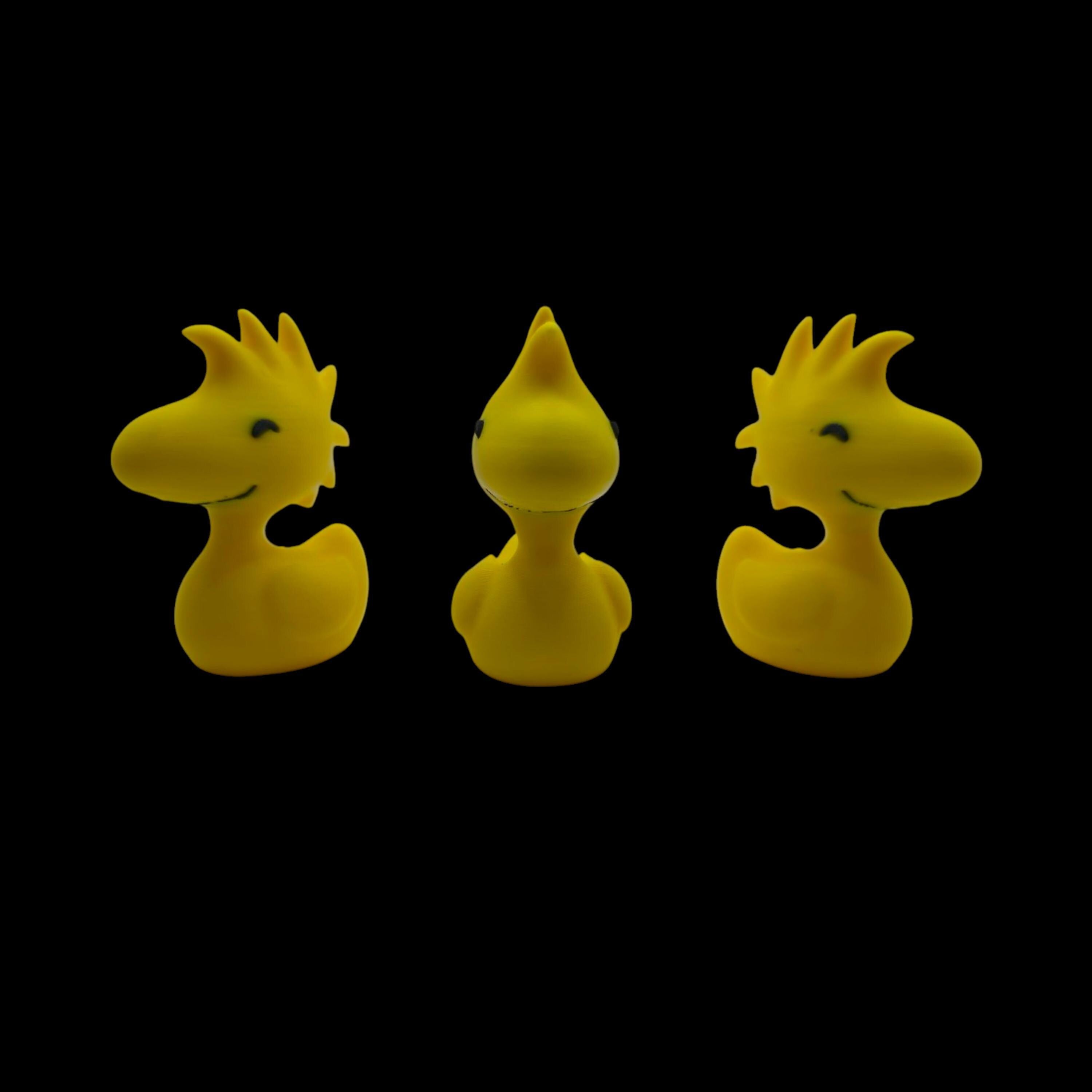Three yellow Woodstock duck figurines are shown from slightly different angles, with the center one facing forward and the outer two facing left and right, against a black background.